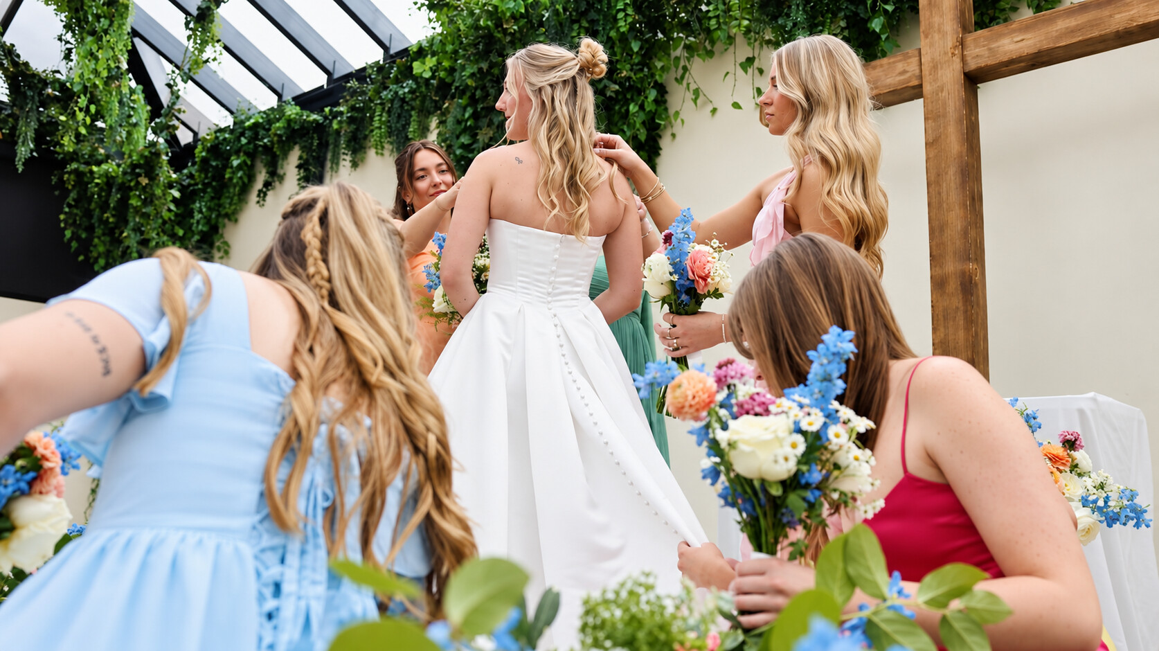 Bri surrounded by her bridesmaids and colorful flowers on her wedding day