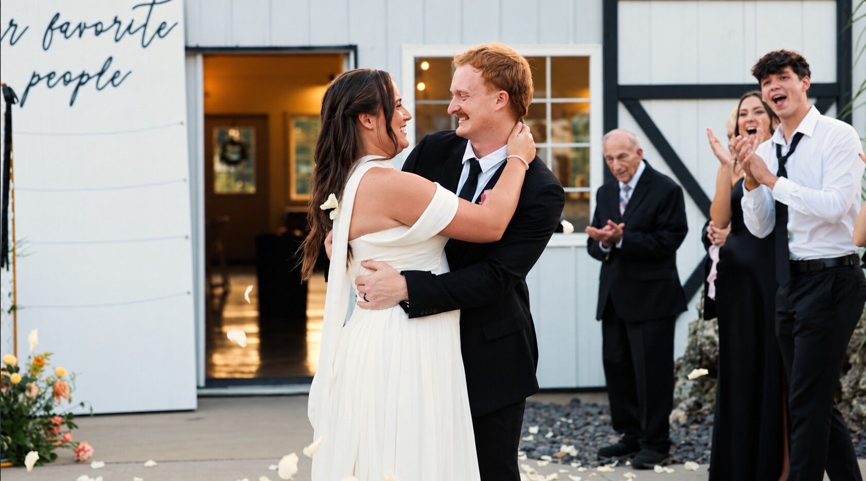 Conner and Grace smiling together as their guests cheer