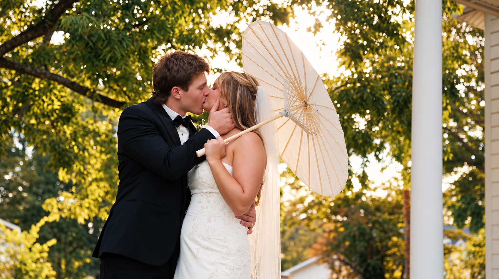 Grace and Jacob kissing beneath a white parasol in the sunshine